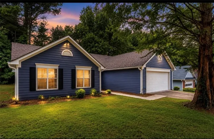 Blue horizontal siding exterior with white trim, a dark shingle roof, and a two-car garage