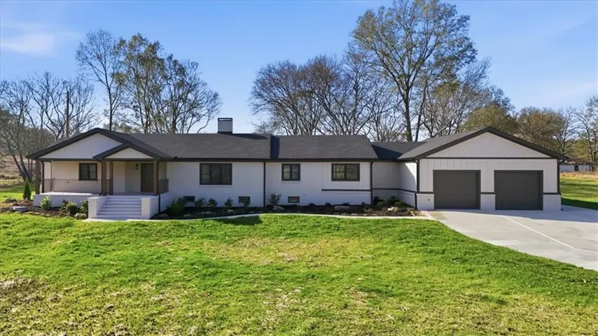 Ranch-style exterior with a contrasting dark roof and light-colored siding