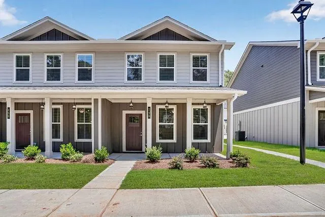 Contemporary end-unit two-story townhouse with a light gray siding upper level and a dark gray lower level