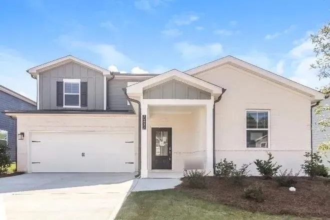 Two-story residence featuring a two-car garage, covered entry, and mixed material exterior
