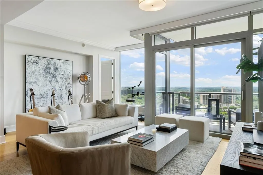 Living room with light wood-style flooring, floor to ceiling windows, and ornamental molding