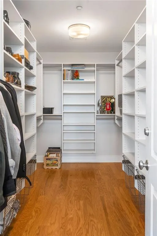 Walk in closet with light wood-style flooring