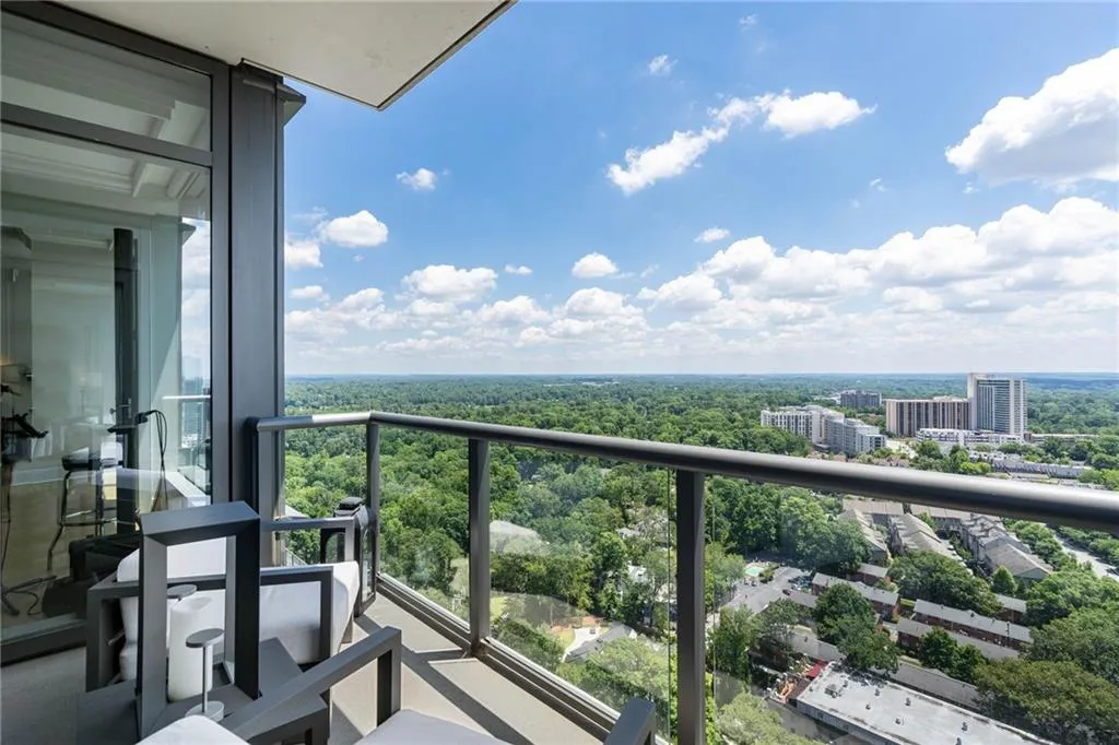 Balcony with view of wooded area and a city view