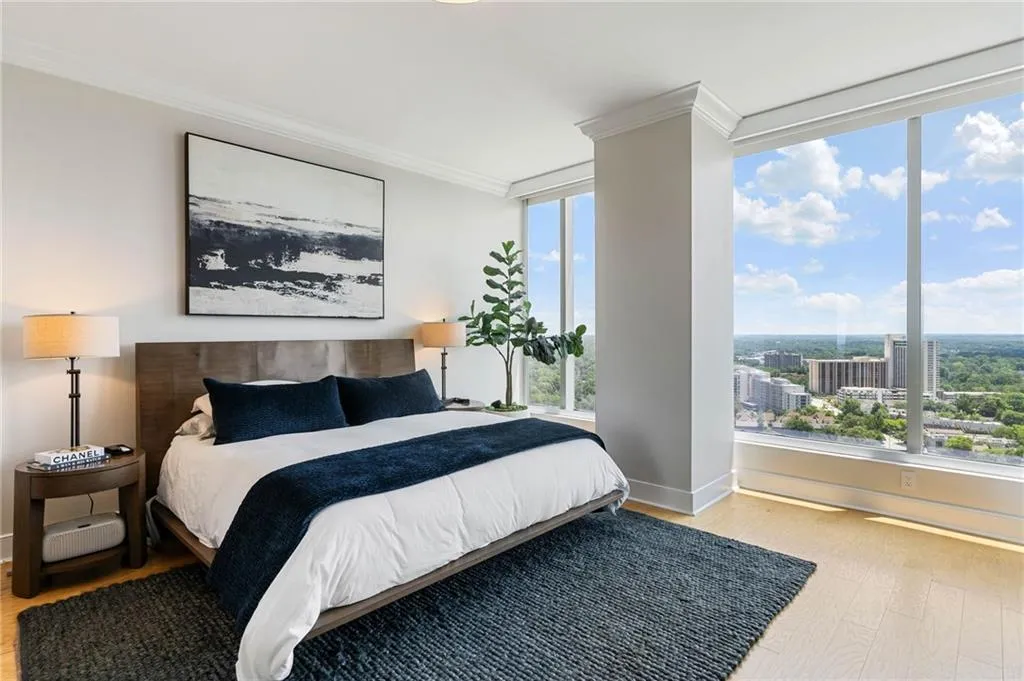 Bedroom with crown molding, light wood-type flooring, and a city view