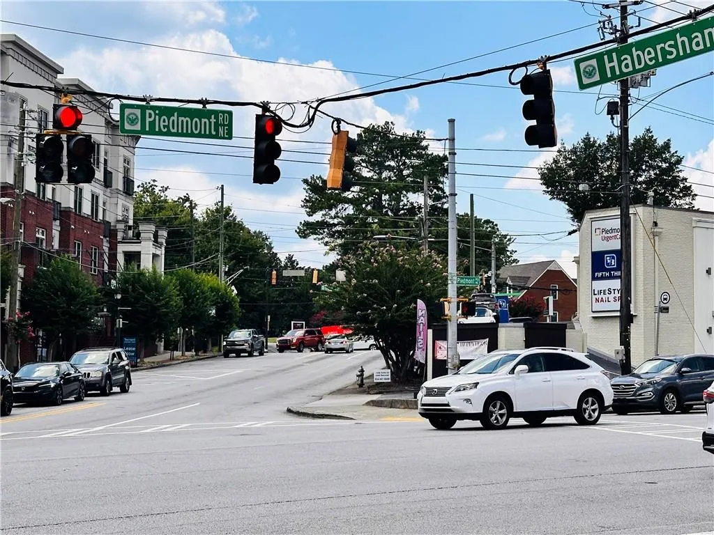 View of asphalt street featuring traffic lights, curbs, and sidewalks