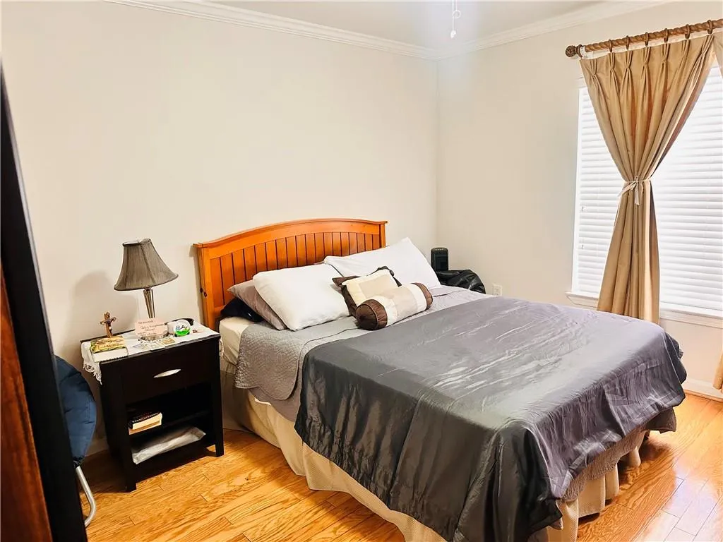 Bedroom featuring light wood-type flooring and crown molding