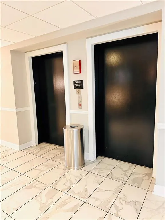 Hall featuring light marble finish floors and elevator