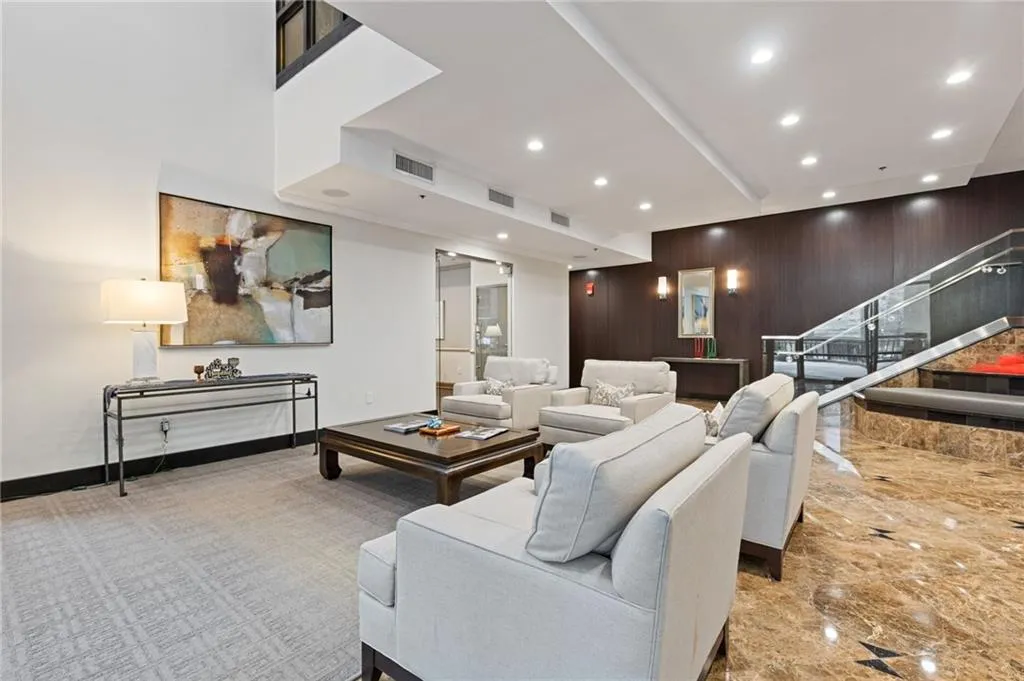 Living area with recessed lighting, wooden walls, marble tiled floors, and stairway
