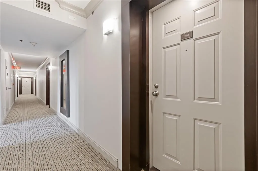 Hallway with crown molding and baseboards