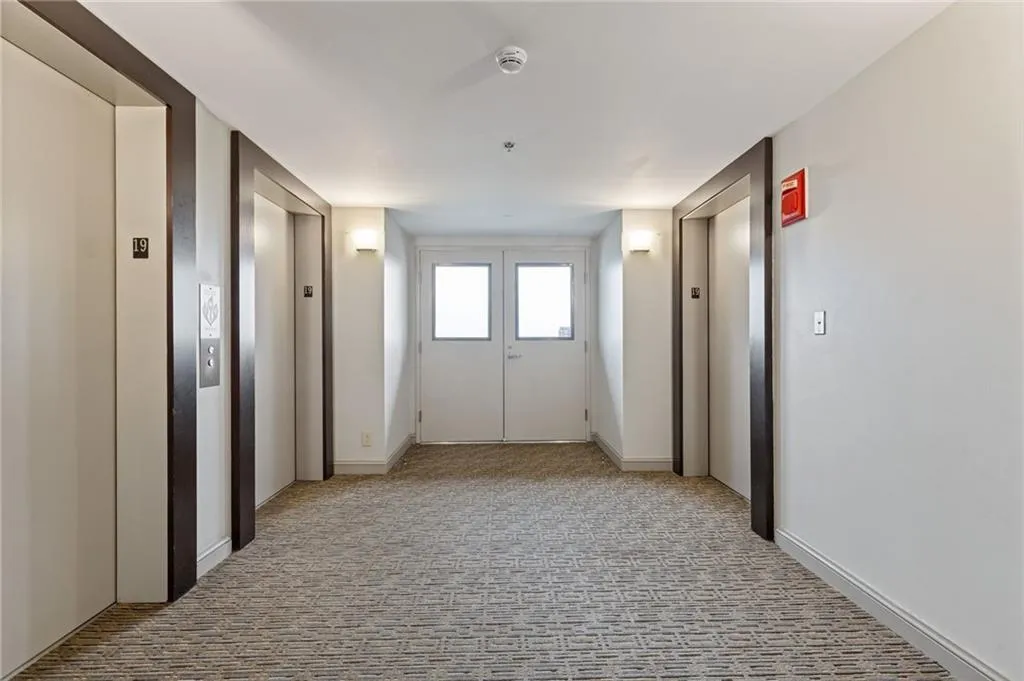Corridor featuring elevator and carpet floors