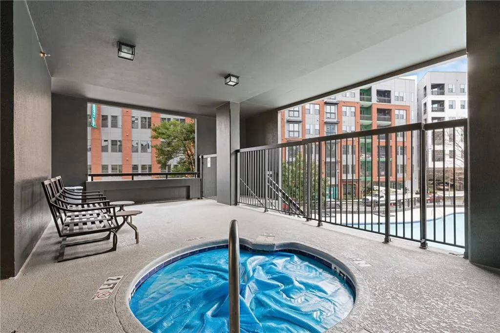 Community pool with a patio area and a hot tub