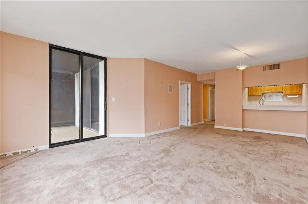 Unfurnished room featuring light carpet and baseboards