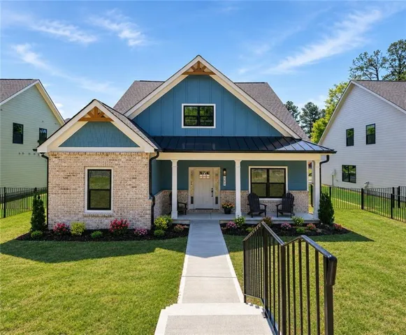 Craftsman-style home featuring a light brick facade and blue siding
