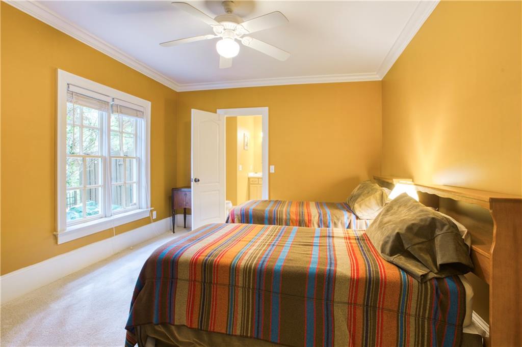 Bedroom #6 with connected bathroom, ceiling fan, light carpet, and crown molding