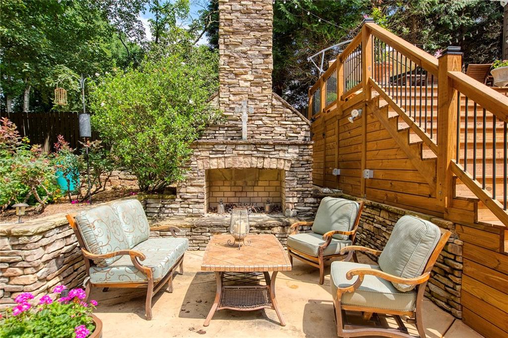 Wonderful outdoor fireplace nestled into lush garden area and overlooking the pool