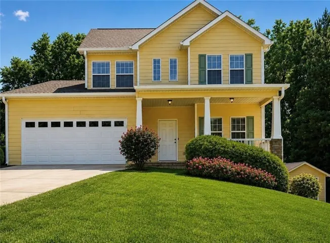 Yellow siding exterior with a covered porch featuring white columns