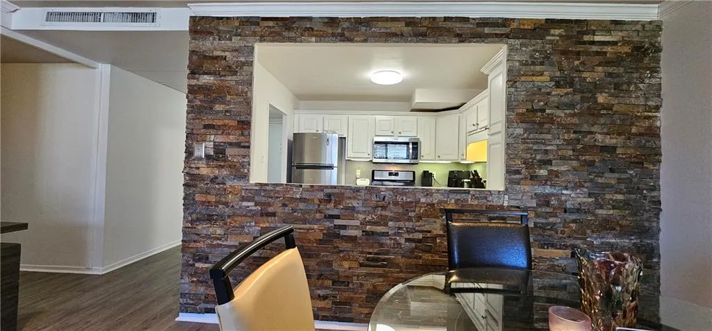 Kitchen featuring stainless steel appliances, dark wood finished floors, and white cabinetry Kitchen featuring stainless steel appliances, dark wood finished floors, and white cabinetry