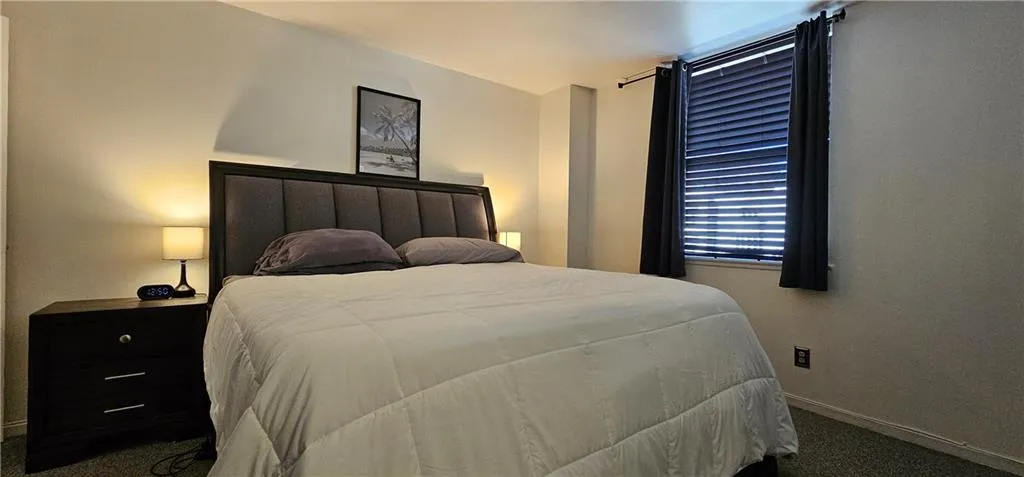 Carpeted bedroom featuring baseboards Carpeted bedroom featuring baseboards