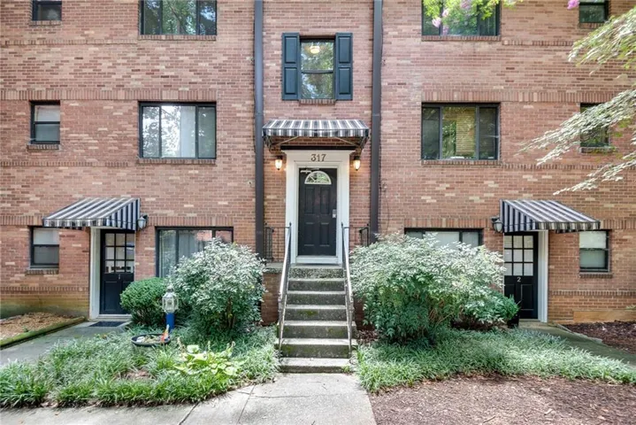 Brick exterior building with multiple entries and striped awnings