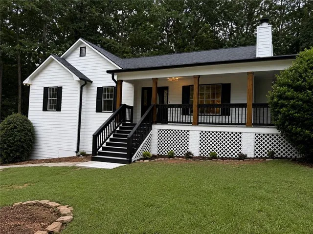 White siding exterior with black shutters and a covered front porch