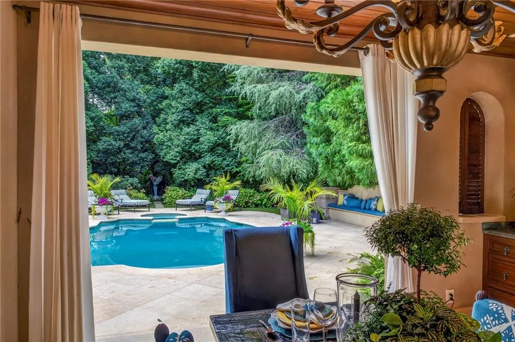 View to pool from outdoor grilling and dining area.   Pool bath off this area.