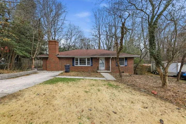 Single story home featuring brick siding, a chimney, driveway, and crawl space
