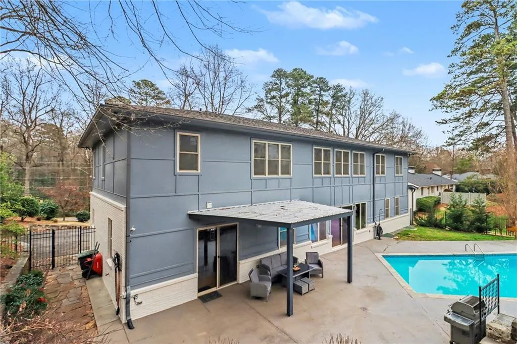 Rear view of house with a patio area and a shingled roof