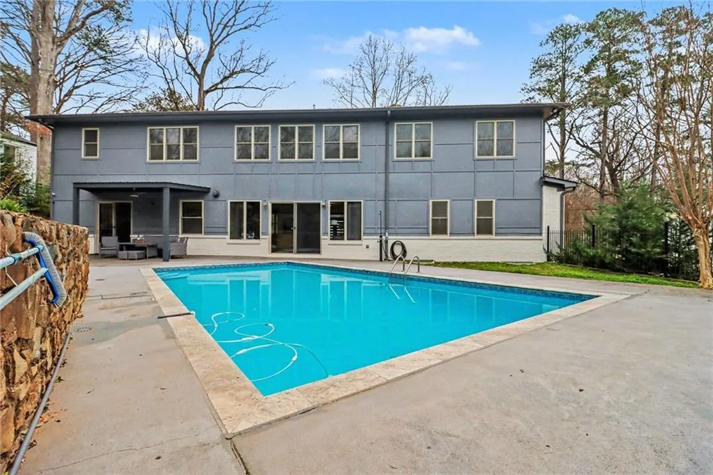 Rear view of property with a patio area, an outdoor pool