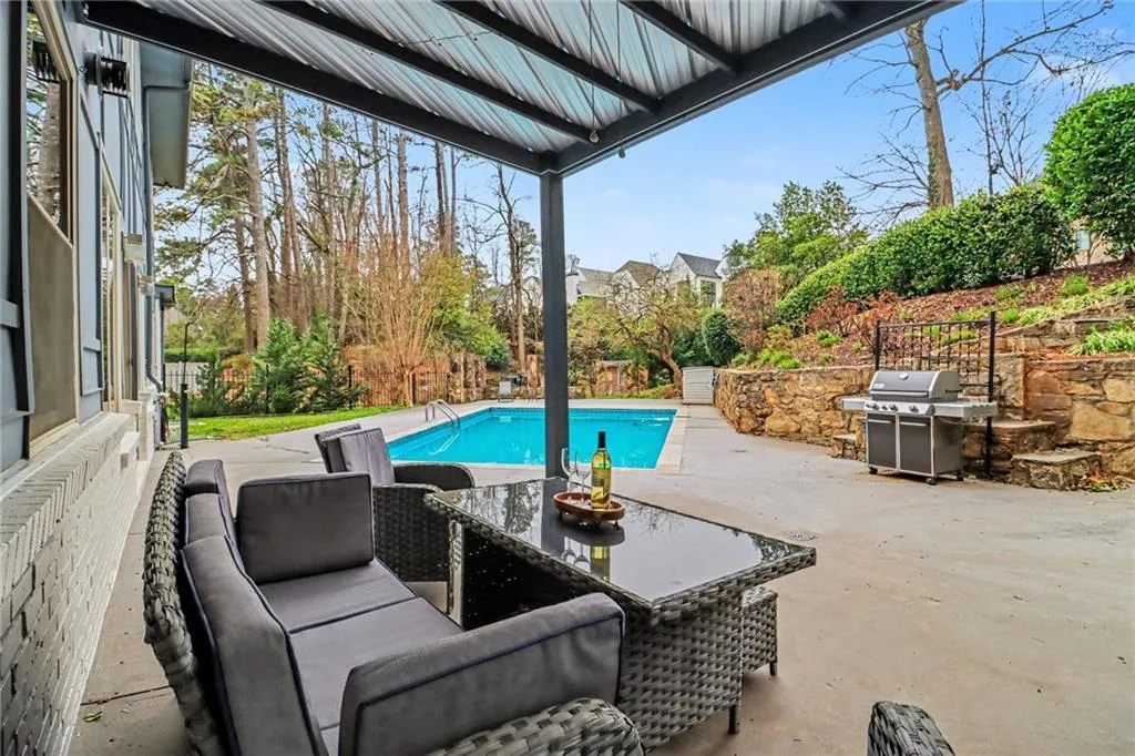 View of swimming pool with grilling area, patio surround, and an outdoor living space