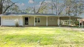 Ranch-style exterior with light-colored siding, a covered front porch, and an attached carport