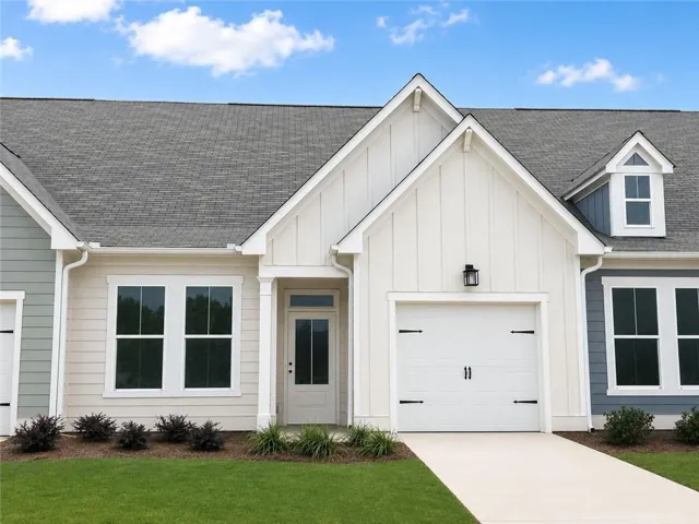 Single-story exterior with board and batten siding, attached garage, covered entryway, and asphalt shingle roof