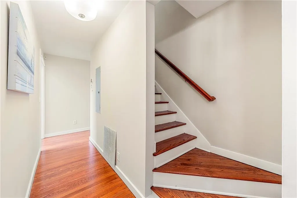 Staircase with wood finished floors and baseboards