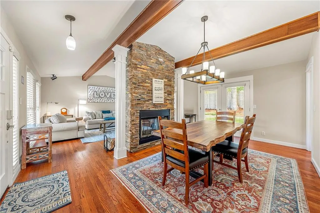 Dining room featuring wood finished floors and a fireplace, front door on left.