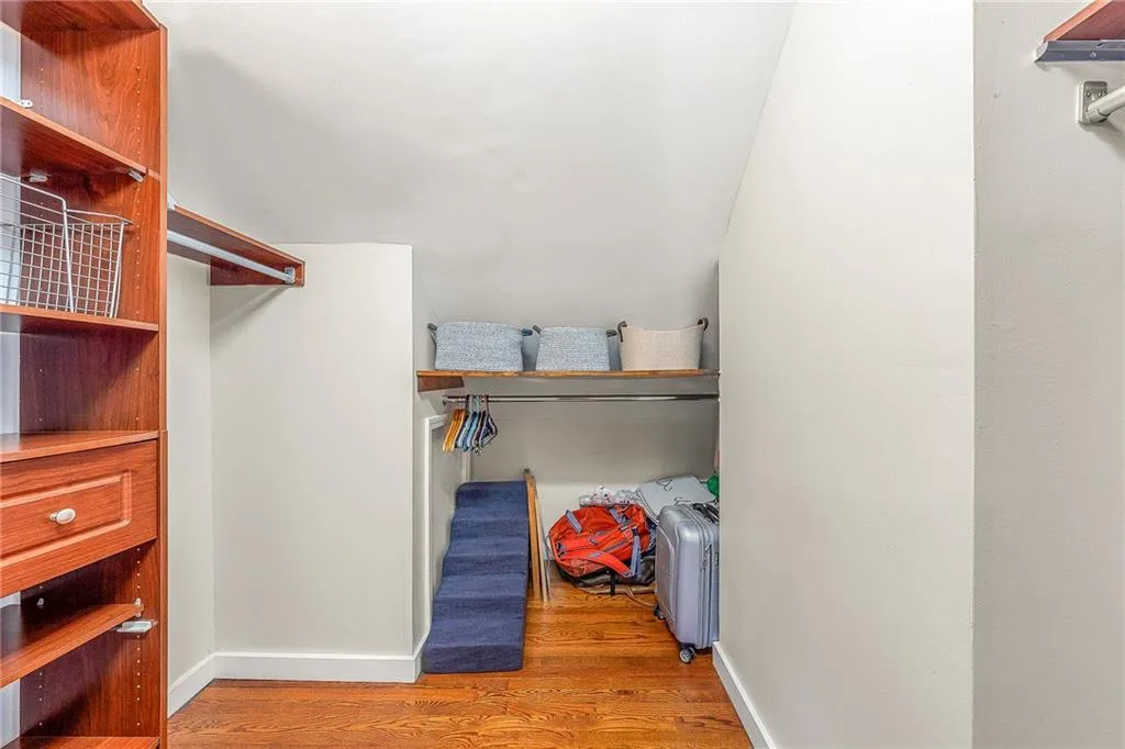 Bedroom with beamed ceiling, wood finished floors, high vaulted ceiling, ceiling fan, and ensuite bath