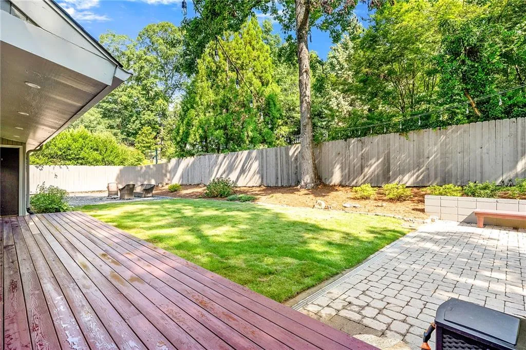 Wooden deck featuring a patio area and a fenced backyard