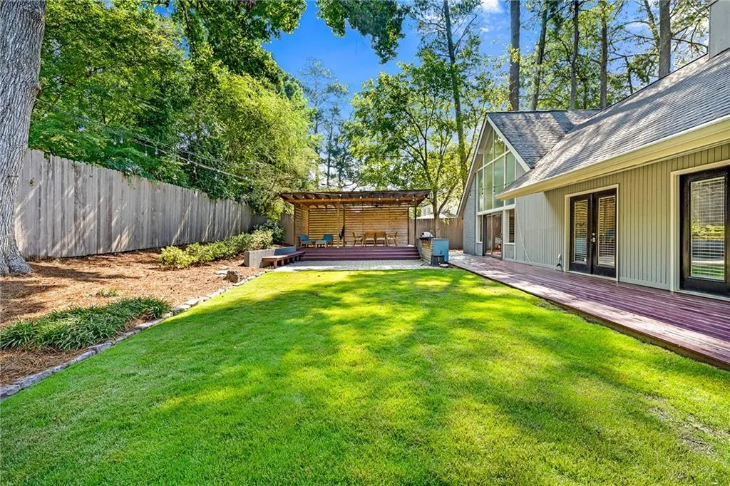 View of yard with a wooden deck and a pergola