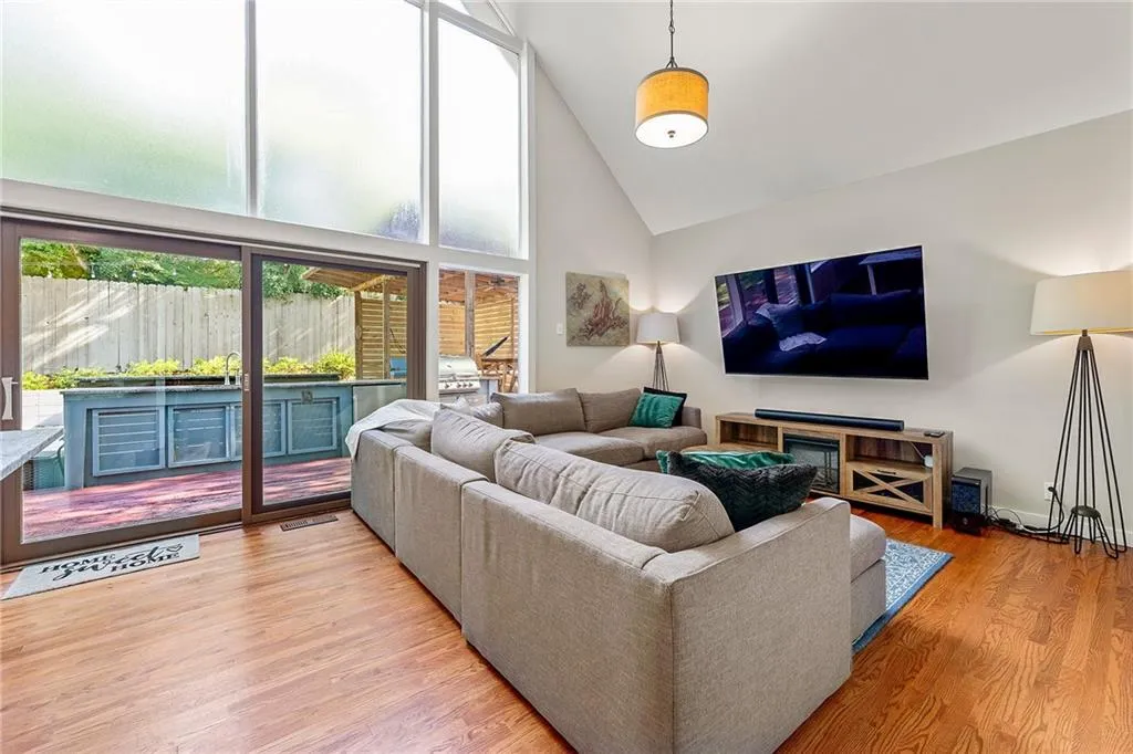 Living room featuring high vaulted ceiling and wood finished floors
