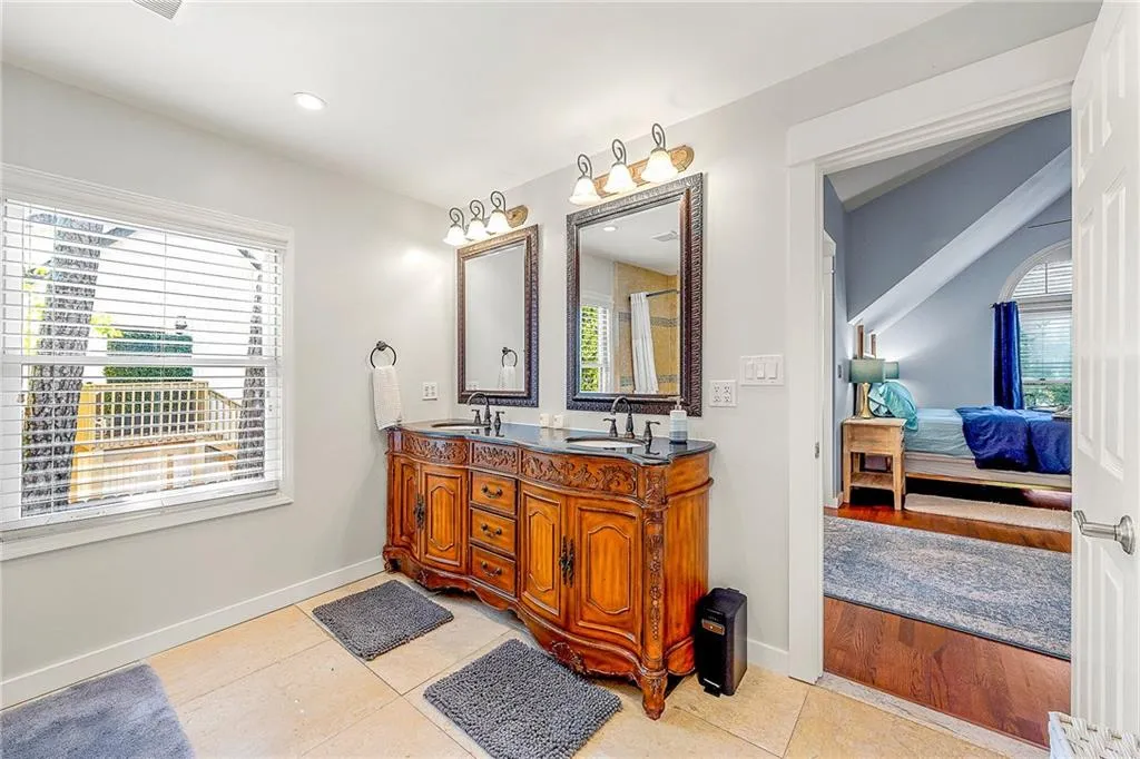 Bathroom with ensuite bathroom, double vanity, and tile patterned floors