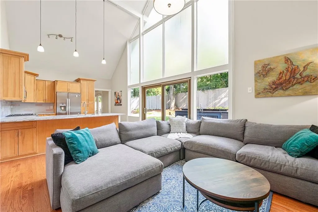 Living room featuring light wood-style flooring and high vaulted ceiling