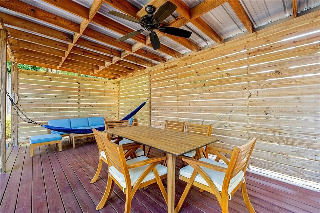 Wooden deck with a patio and a fenced backyard