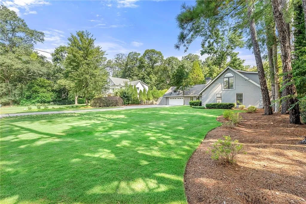 View of green lawn featuring view of scattered trees