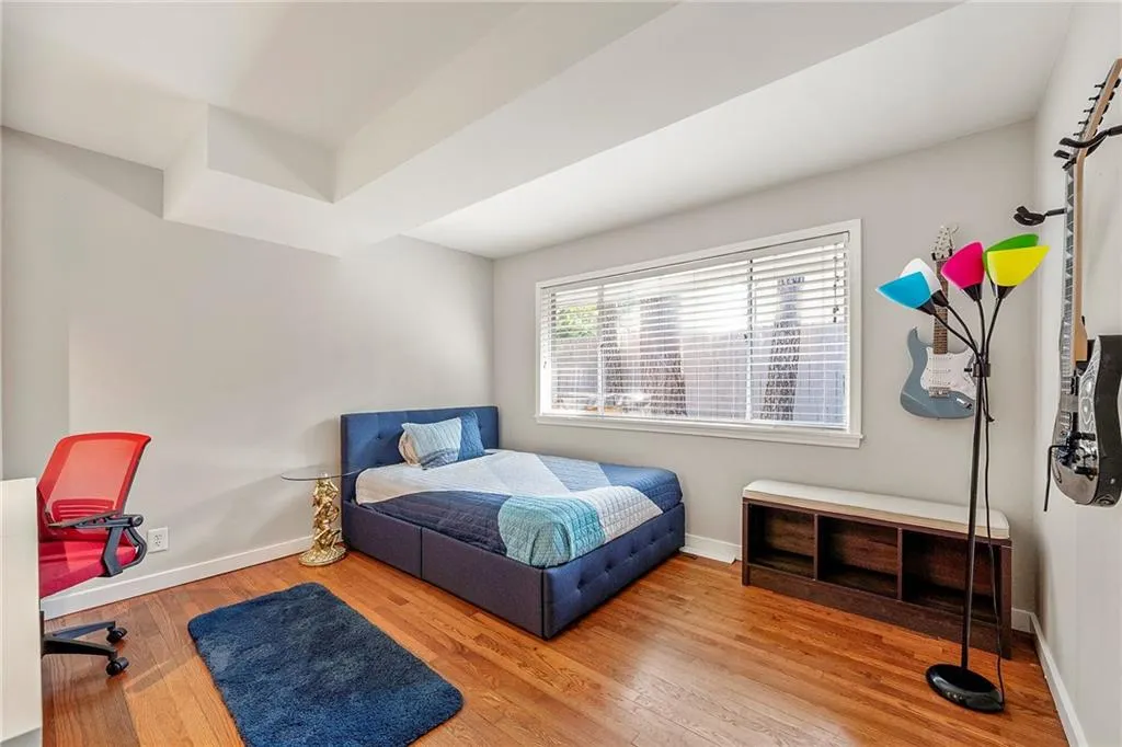 Bedroom with wood-type flooring and a desk