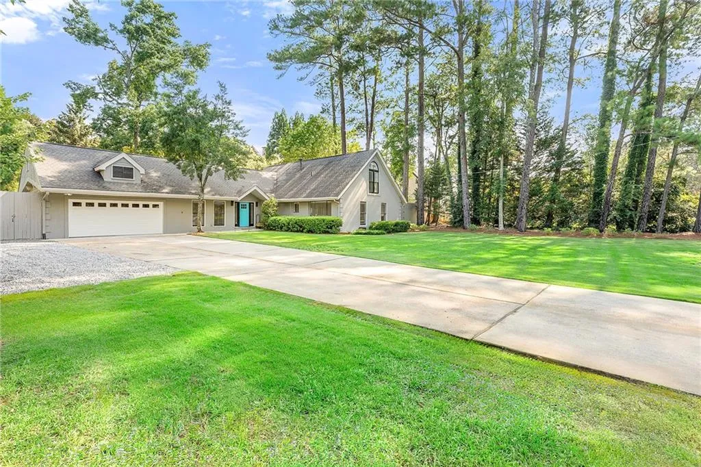 View of front of property featuring driveway, a garage, and a front yard