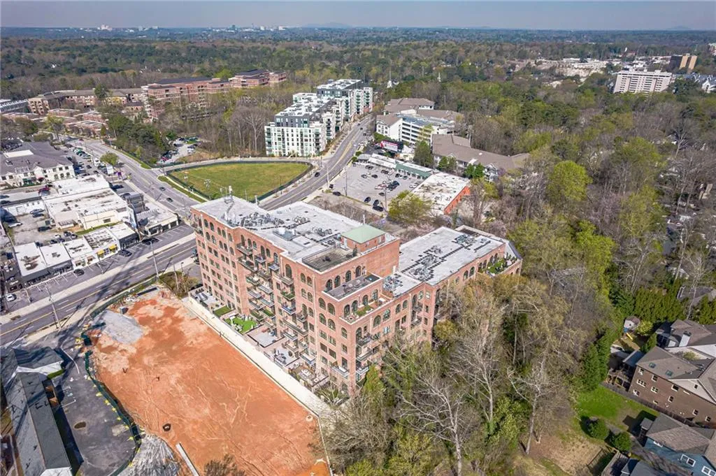 Multi-story brick building featuring arched windows, multiple balconies, and a flat roofline