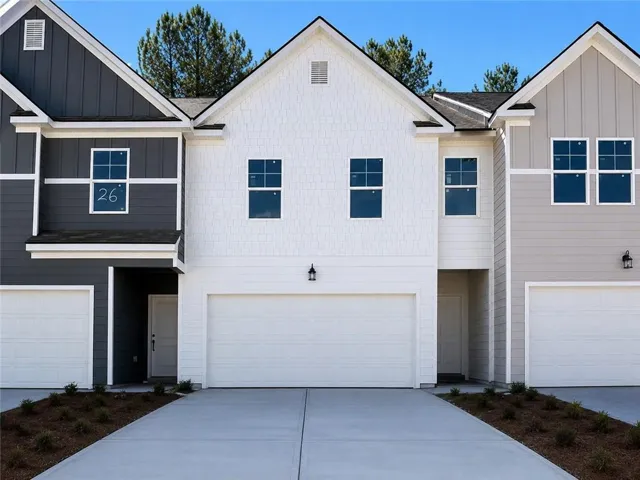Contemporary facade featuring a prominent gable roofline, white horizontal siding, and a two-car garage