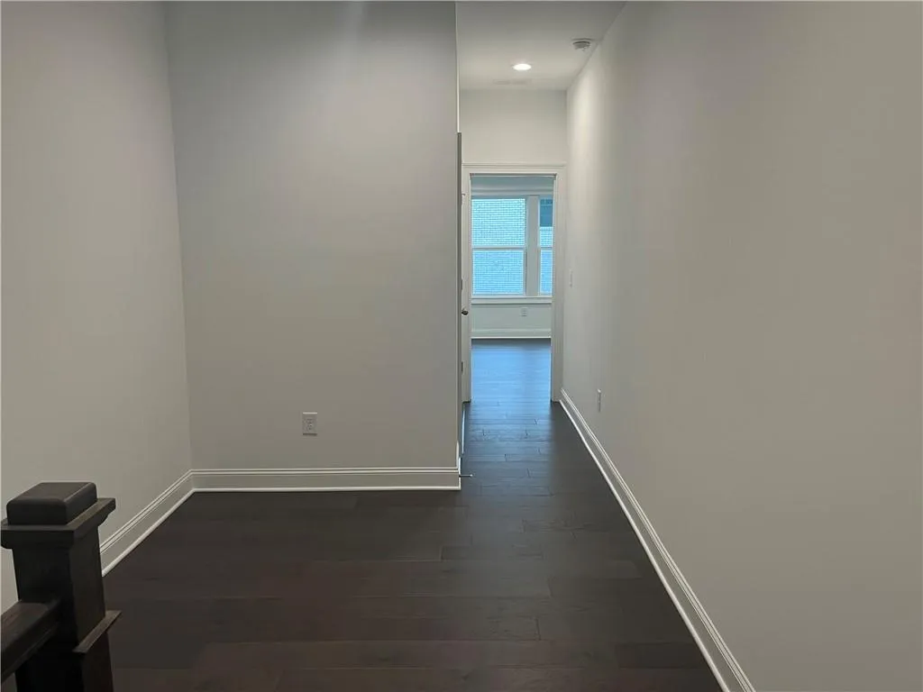 The upstairs hallway is spacious with hardwood flooring and a great space for a desk or seating area.