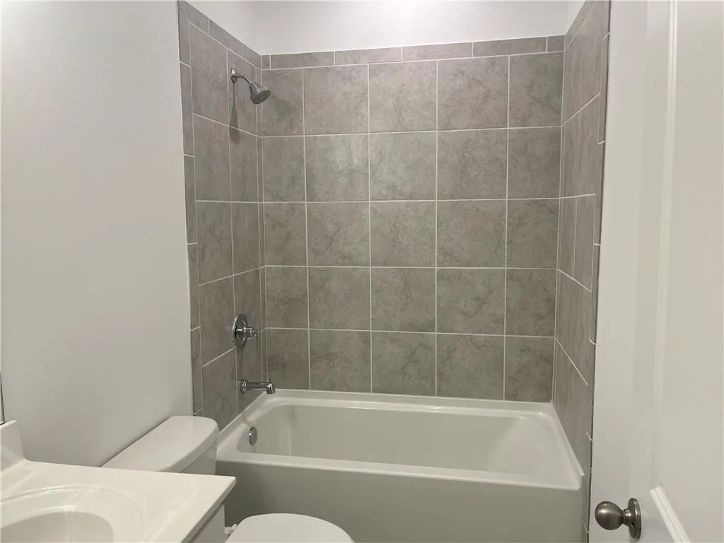 The ensuite secondary bath upstairs has tiled shower walls.