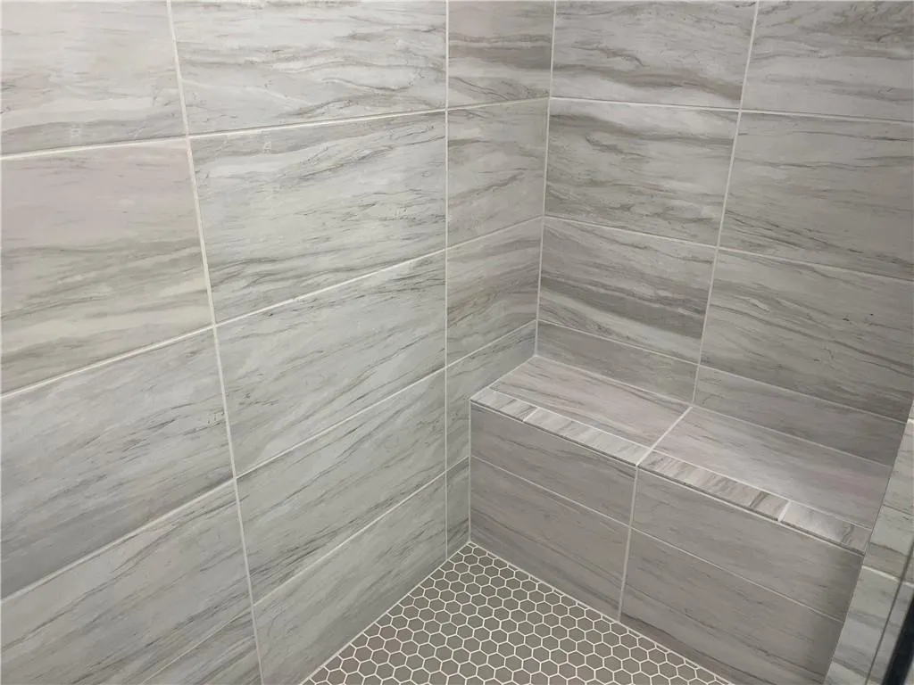 The Primary Shower has tile to ceiling walls and a shower seat.