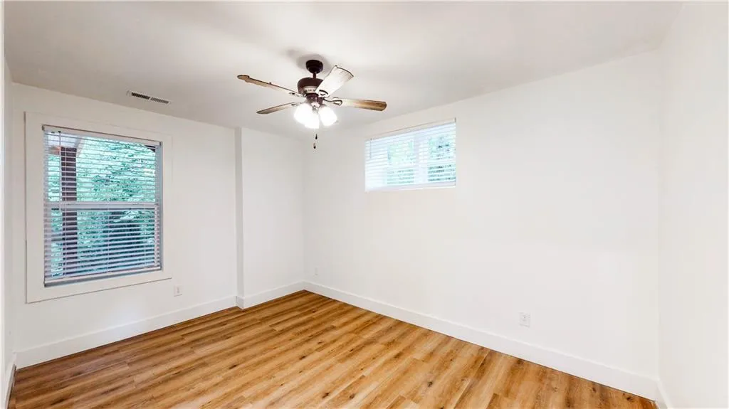 Unfurnished room with wood finished floors and ceiling fan