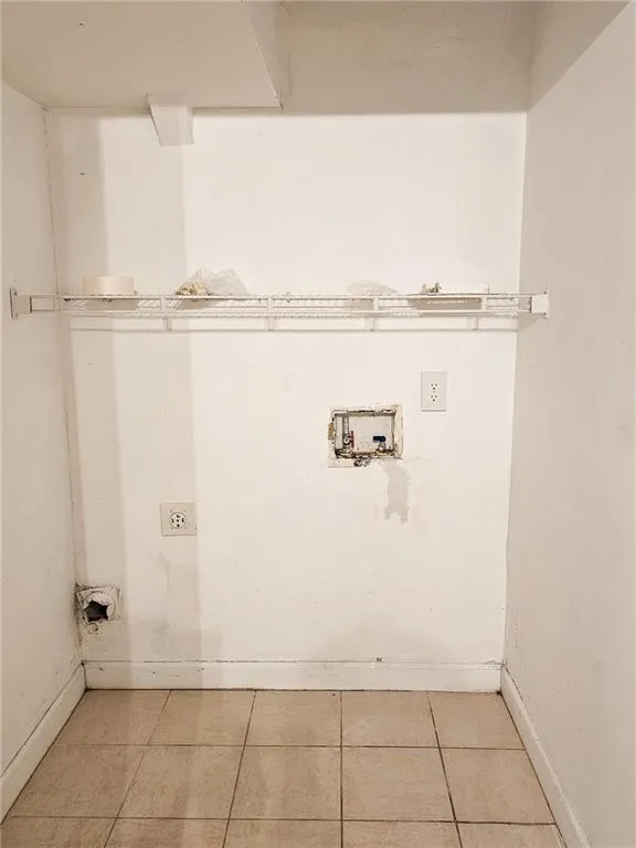 Washroom with tile patterned floors, hookup for a washing machine, and electric dryer hookup